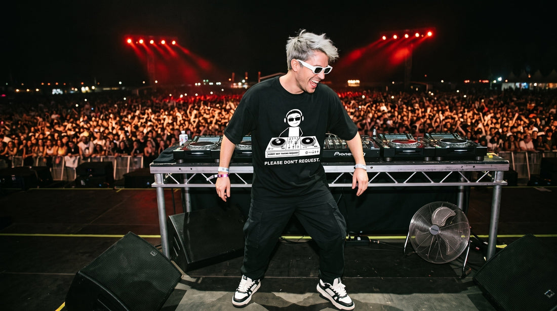 Male DJ wearing NYSH DJ Clothing black graphic oversized t-shirt performing live on mainstage festival booth
