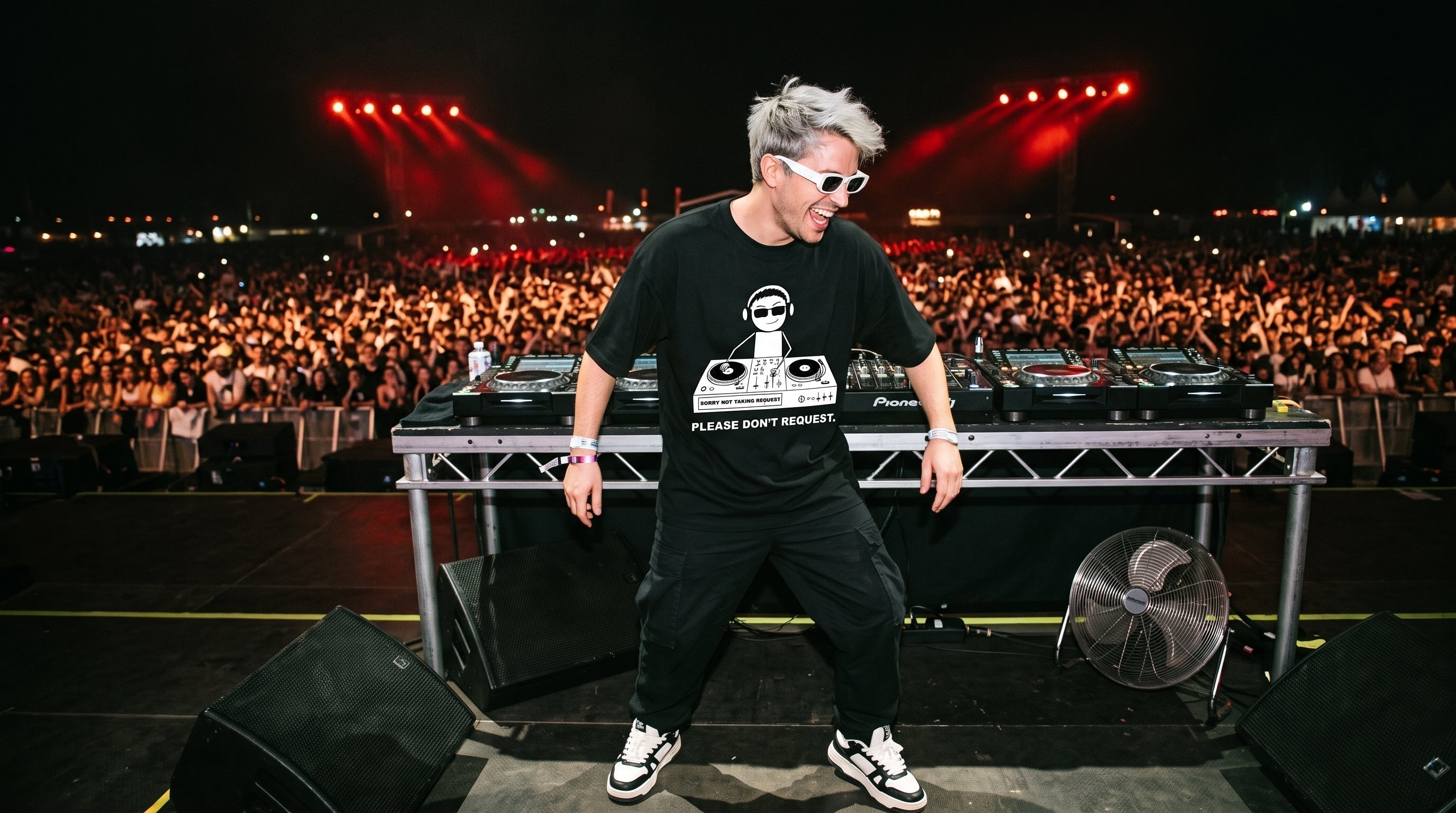 Male DJ wearing NYSH DJ Clothing black graphic oversized t-shirt performing live on mainstage festival booth