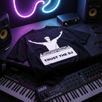 Trust The DJ Quote Black Oversized T-Shirt flat lay on music studio desk neon synth