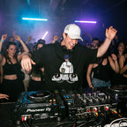 DJ wearing Chill Session DJ graphic oversized t-shirt performing on Pioneer decks in front of cheering club crowd