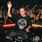 Female DJ wearing cyberpunk skull graphic oversized t-shirt mixing on decks with energetic crowd under red lights