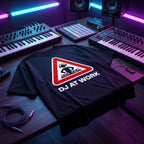 Black oversized DJ t-shirt with DJ At Work warning sign graphic laid flat under neon purple and blue studio lighting