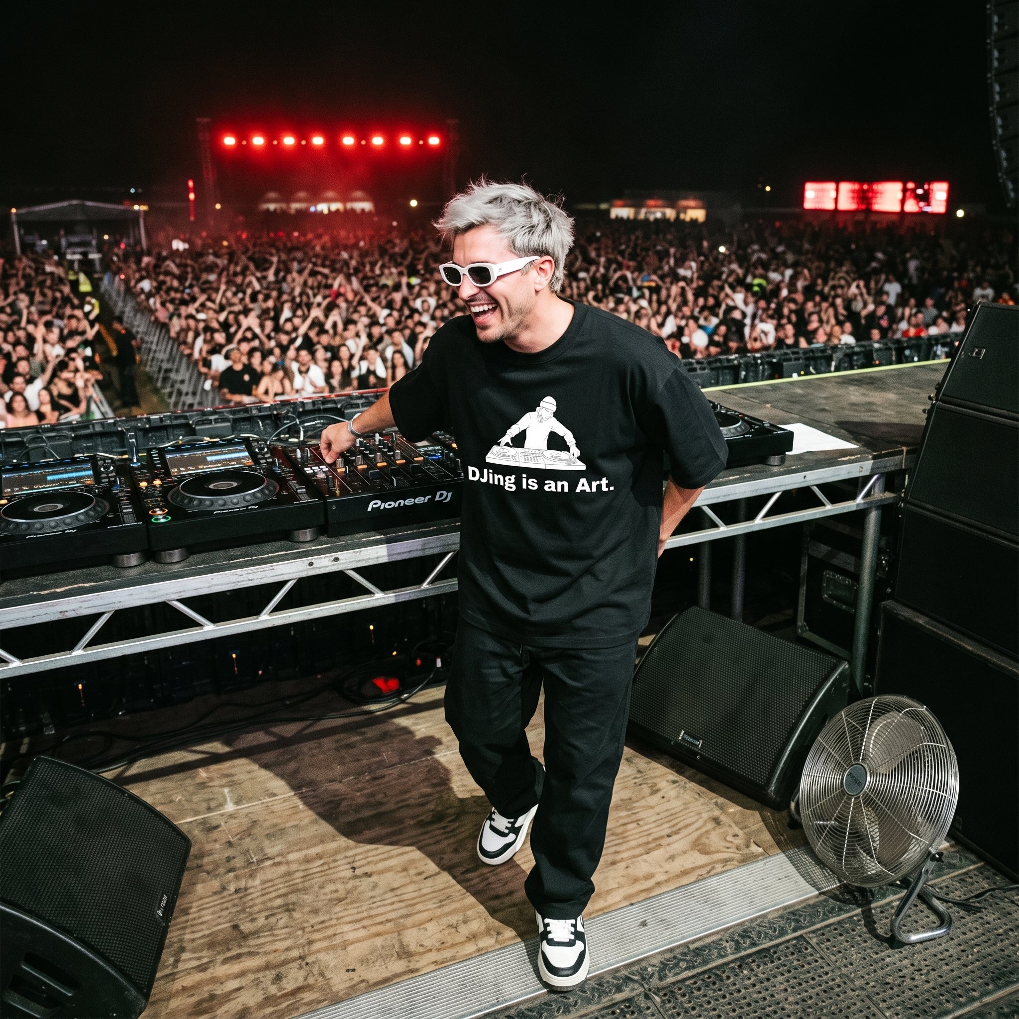 DJ in DJing Is An Art oversized black t-shirt performing on outdoor festival stage in front of large crowd