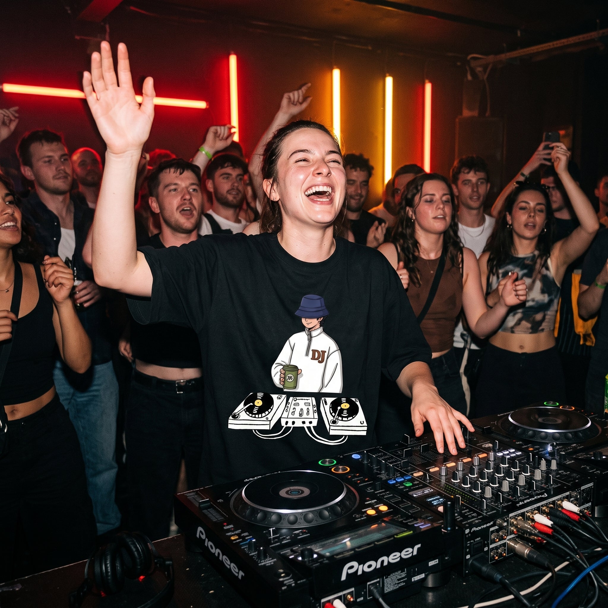 Female DJ wearing Chill Session DJ graphic oversized t-shirt mixing on decks with energetic crowd under red lights