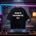 "God's Favorite DJ" confident quote print on a black oversized streetwear tee.