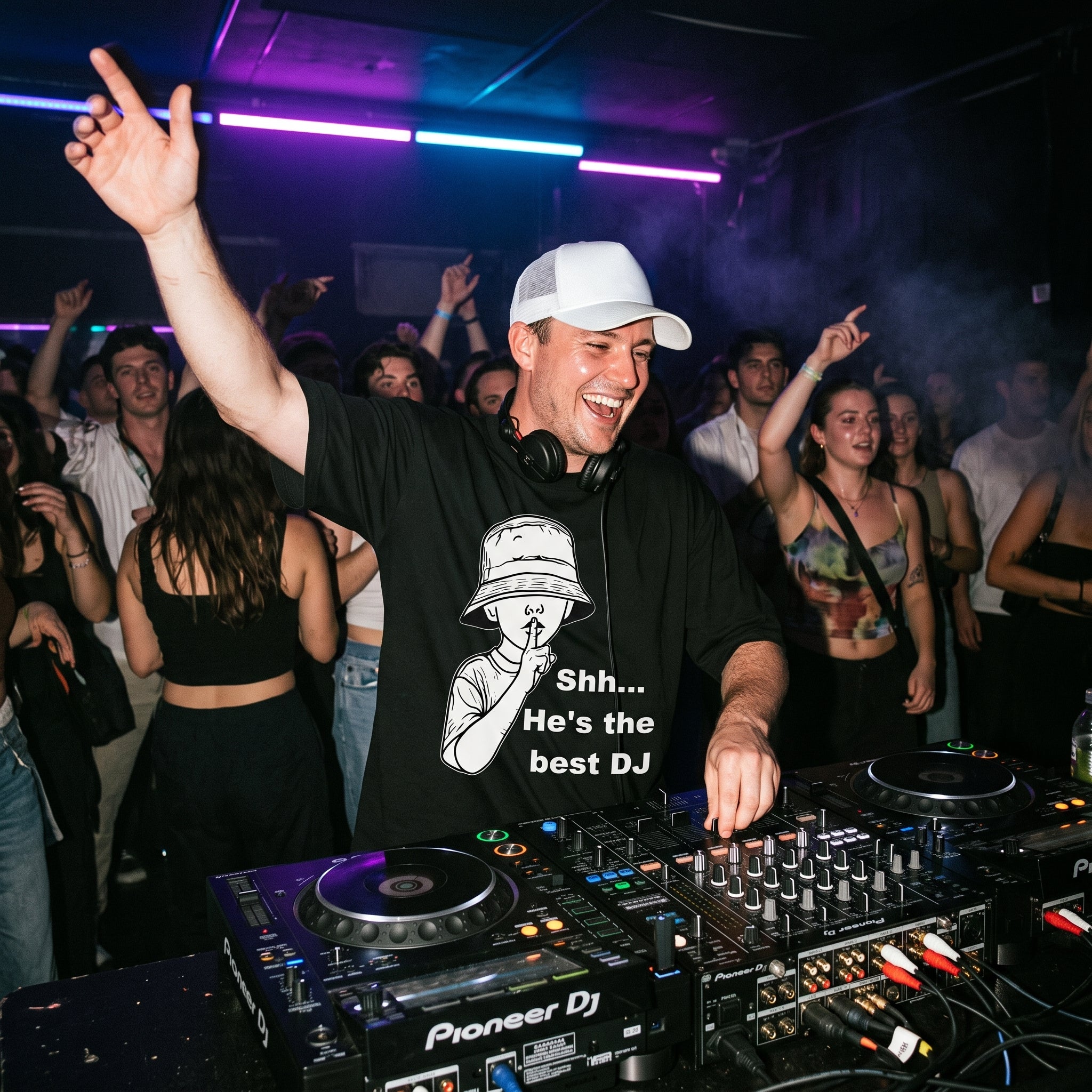 DJ wearing Shh He's The Best DJ oversized t-shirt performing on Pioneer decks in front of cheering club crowd