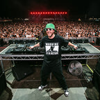 Male DJ in Warning DJ In Action Black Oversized T-Shirt on festival stage massive crowd