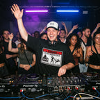 DJ wearing Danger DJ Do Not Disturb Oversized T-Shirt performing in club hand raised