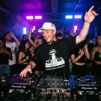 DJ wearing Sorry Not Taking Request oversized t-shirt performing on Pioneer decks in front of cheering club crowd