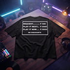 Black oversized t-shirt with funny DJ request rate card quote graphic, flat lay on wooden desk with DJ controller and vinyl records