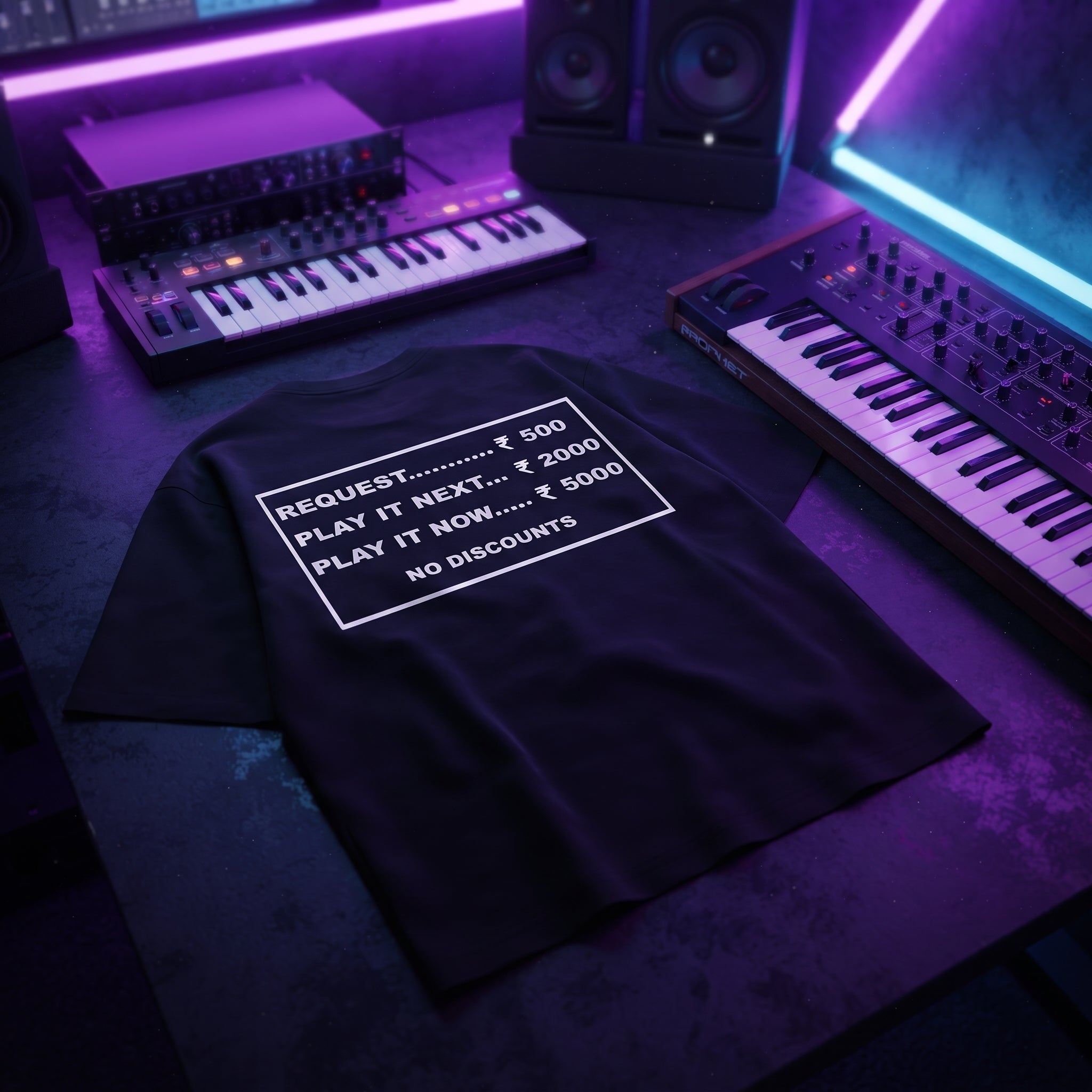 Black oversized DJ t-shirt with request rate card pricing quote laid flat under neon purple studio lighting