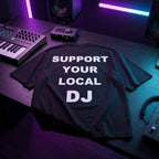 Black oversized DJ t-shirt with Support Your Local DJ quote laid flat under neon blue and purple studio lighting