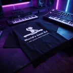 Black oversized DJ t-shirt with World's Best DJ quote laid flat under neon purple studio lighting