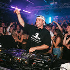 DJ wearing World's Best DJ quote oversized t-shirt performing on Pioneer decks in front of cheering club crowd